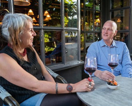 Becky and Andy sitting chatting at a small table outside the front of a restaurant