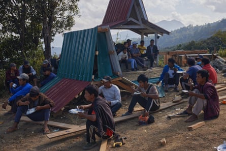 Villagers rest to eat while they construct a memorial to a fallen soldier in Hriang Kahn, Chin state
