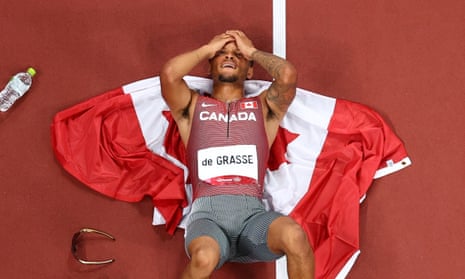 Andre De Grasse lies on the track after winning the men’s 200m title at the Tokyo Olympics