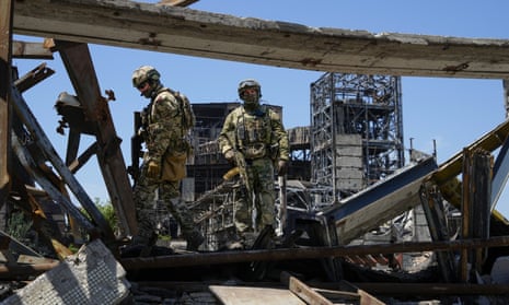 Russian soldiers walk through the debris of the Azovstal iron and steel works, June 2022.