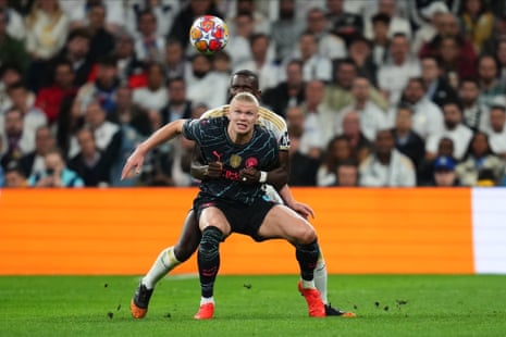 Erling Haaland of Manchester City is marked closely by Antonio Rudiger of Real Madrid.