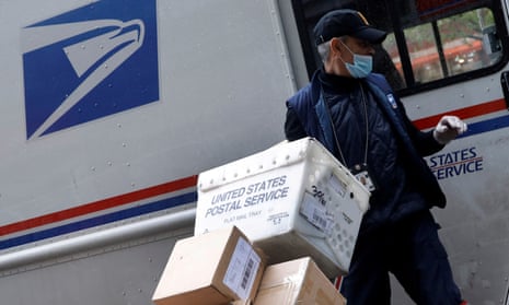 A United States Postal Service (USPS) worker unloads packages from his truck, New York, April 2020.