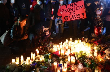 person holds sign that says 'the problem is guns'