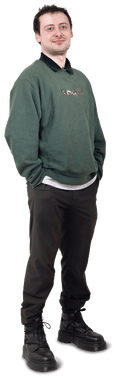 Josh full body shot wearing green jersey, dark trousers, stack heel black lace-up boots