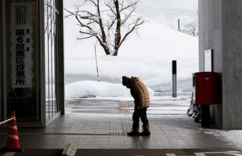 A voter at a polling station with snowy fields in the background