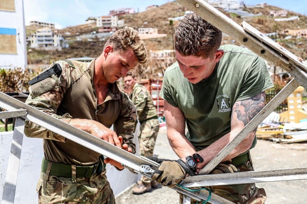Royal Marines move a collapsed radio mast that has been blocking crucial access within the police station on Tortola.