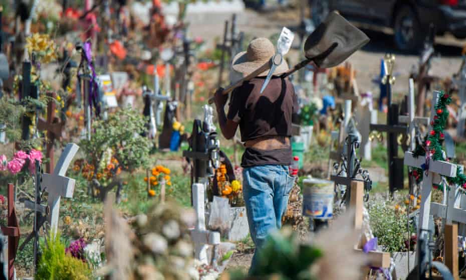 A gravedigger works at a cemetery in Valle de Chalco in Mexico where the pandemic has now killed more than 100,000 people.