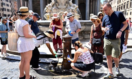 People queue to fill bottles with water at a public tap in Rome on 11 July.