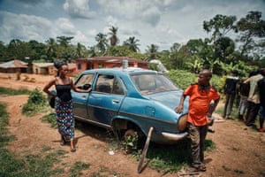 A woman and man next to a derelict car