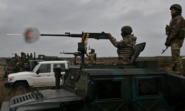 Ukrainian soldiers firing machine guns mounted on the top of military vehicles