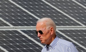 Joe Biden walks past solar panels while touring the Plymouth Area Renewable Energy Initiative in Plymouth, New Hampshire.