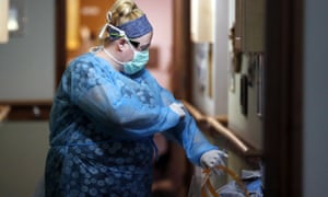 A nurse prepares for work at a nursing home in England.