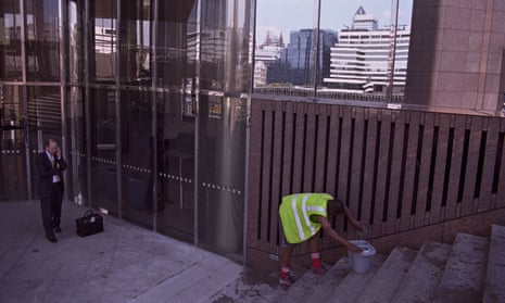 A cleaner in front of a building in the City of London