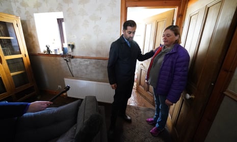Humza Yousaf speaks to Kim Clark as he looks at water damage in her house during a visit to Brechin, in Angus.