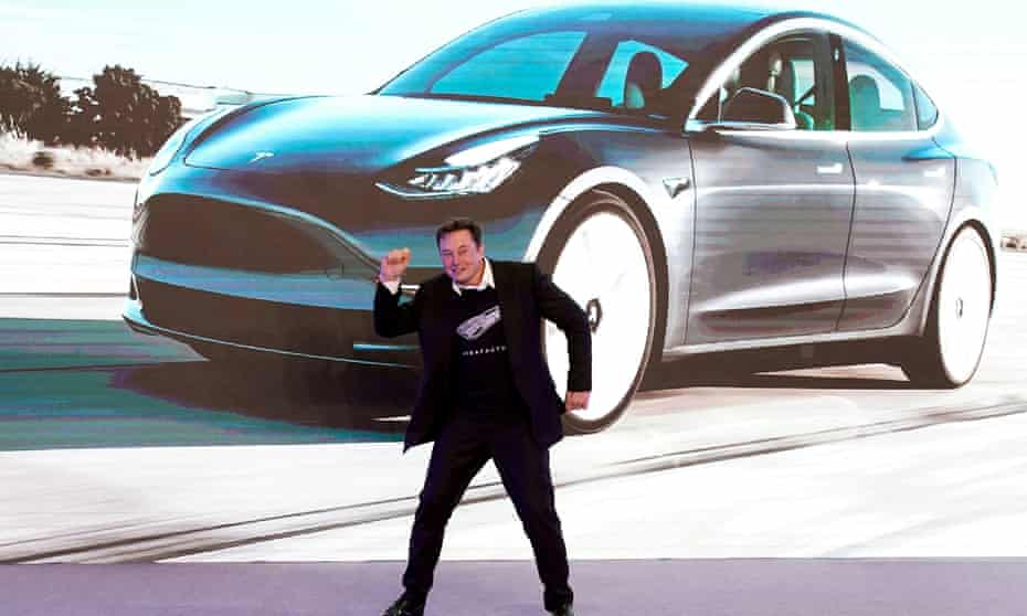 Tesla CEO Elon Musk against a backdrop of one of the company’s electric cars.