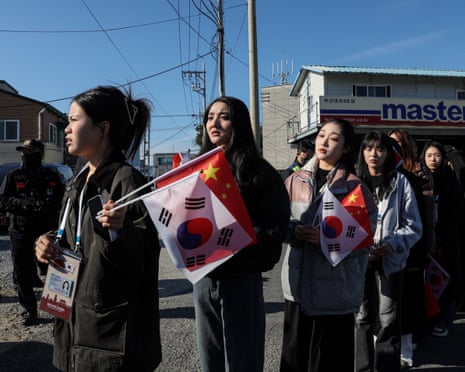 Pro-China supporters hold China and South Korea flags near Gimhae airport in Busan