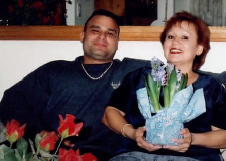 A younger man and an older woman smile.