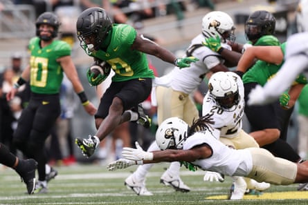 Oregon running back Bucky Irving, left, dodges a tackle by Colorado’s Cam’Ron Silmon-Craig, center, and LaVonta Bentley, right, during the first half of Saturday’s game.