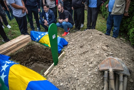 A tiny coffin wrapped in the Bosnian flag sits ready to be lowered into its grave.