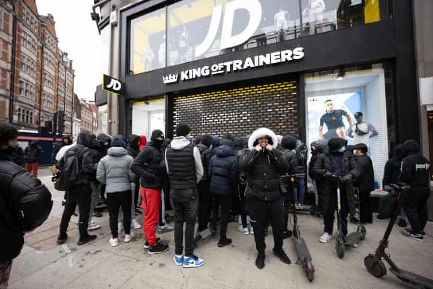 People waiting to buy trainers queue outside JD Sports in Oxford Street in London.