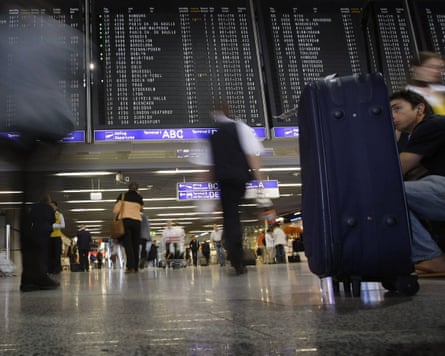 Passengers walk under the flight schedule board inside the main terminal of Frankfurt’s airport