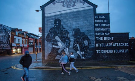A resident walks past a loyalist paramilitary mural in Belfast in April 2023.
