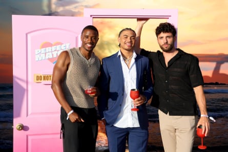 Троє чоловіків в позі і кухоль для камери.