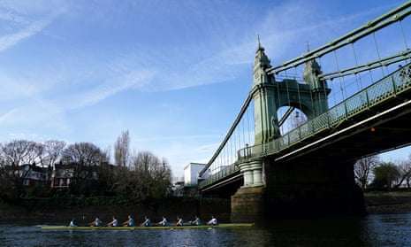 The Cambridge men's team pass under Hammersmith Bridge during a training session on the River Thames.