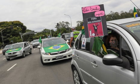 A woman holds up a sign reading ‘Brazilian lives matter. Out Bolsonaro!’ during a motorcade in São Paulo.
