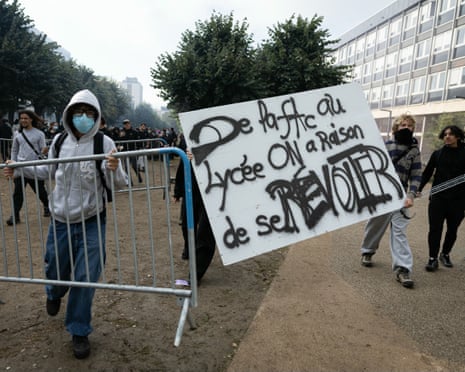 Students move barriers and hold a banner reading "From university to secondary school, we're right to rebel" as they carry out a blocking protest at the Strasbourg University, in Strasbourg, eastern France.