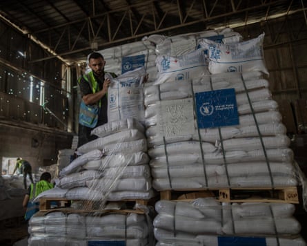 Bags of flour piled high in a warehouse