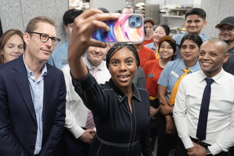 Kemi Badenoch takes a selfie with staff members during a visit to McDonalds in Ruislip, west London.