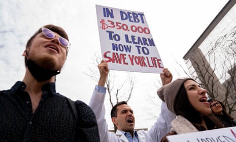 People hold signs during a Cancel Student Debt rally outside the US Department of Education in Washington DC, on 4 April.