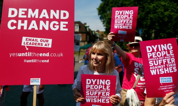 Supporters of a bill legalising assisted dying hold placards outside parliament in Westminster, central London.