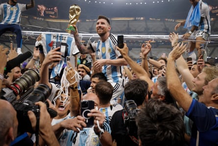 Lionel Messi shows off the World Cup trophy to fans as he is carried around the pitch during celebrations after the 2022 World Cup final between Argentina and France