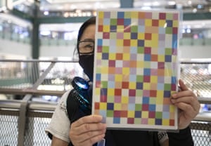 A woman holds up a self-printed mini 'Lennon Wall' during a protest in a mall in Hong Kong in August.