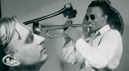 A scene from Akomfrah’s 2021 video installation The Unfinished Conversation. A trumpeter playing and a man with his eyes closed.