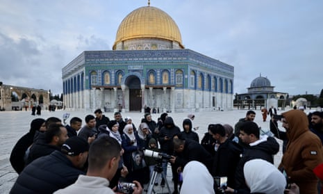 A group of Palestinians gather at the Dome of the Rock in Jerusalem to observe the new crescent moon on Tuesday.