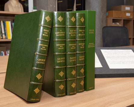 Four green bound items and a folder on desk