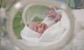 A newborn baby in a hospital incubator