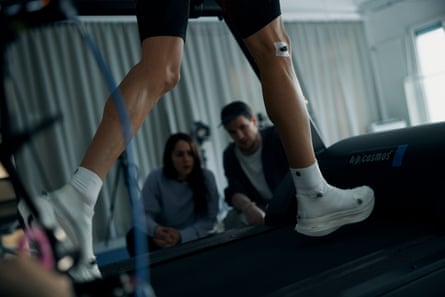 A pair of On shoes being put through their paces on a treadmill with staff looking on in the background