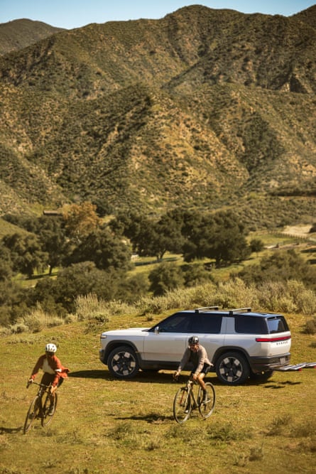 The Rivian R2 car adjacent peaks and 2 cyclists
