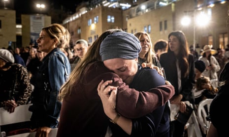 Mourners hug after lighting candles in memory of the 1,400 victims.