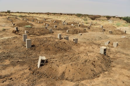 A sandy area the size of a football pitch with a large number of mounds and breezeblocks
