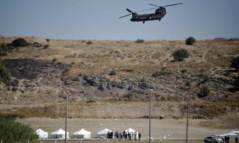 A Greek air force helicopter hovers over a military area on Lesbos as officials prepare a tented area for refugees after a series of fires in the island’s Moria camp. 