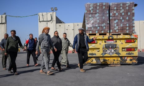 Egyptian truck drivers walks back to their aid trucks after being escorted out of the checking area in Kerem Shalom, Israel.