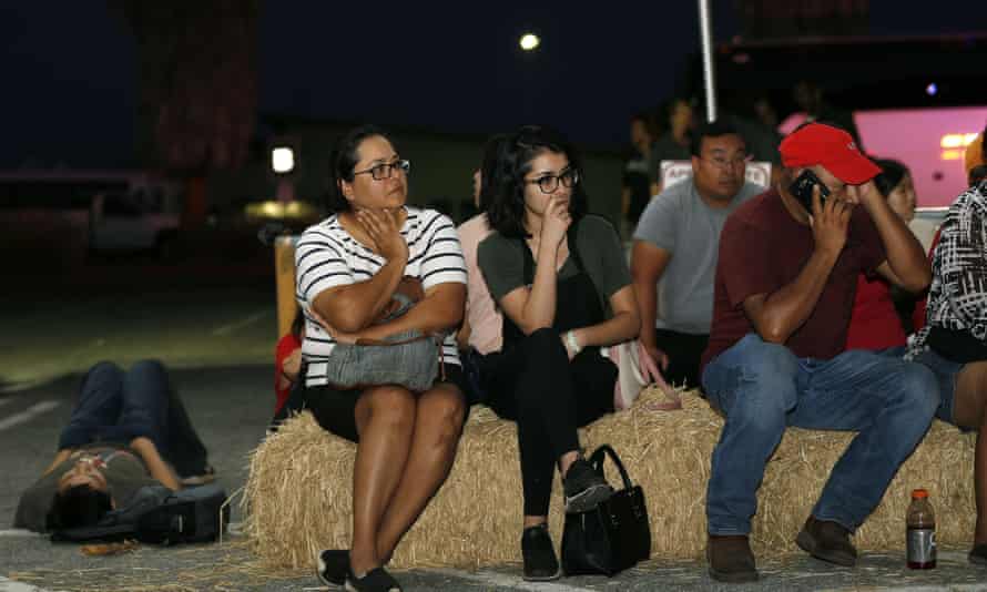 Ana Lilia Cano, left, with daughter Paulina Perez, and Gildardo Leyva, right, wait for relatives at a reunification centre following the shooting.
