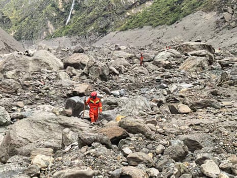 Rescue workers walk through a flood-hit area.