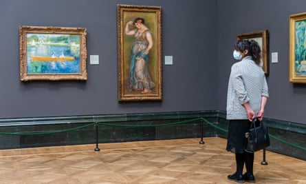 On 4 July 2020; a woman wearing a face mask looks at paintings during preparations for the reopening of the National Gallery.