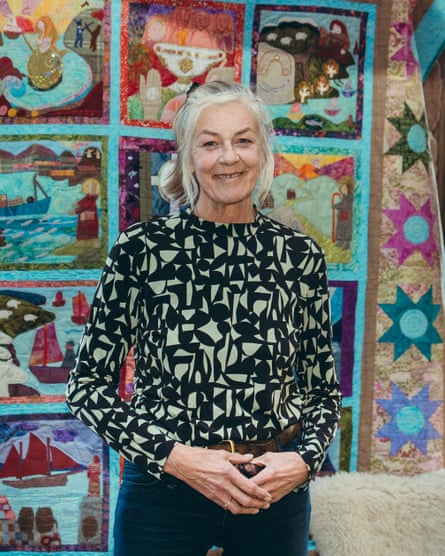 An older woman stands by what looks like children's artworks